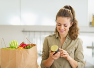Young housewife exploring purchasings after shopping in kitchen